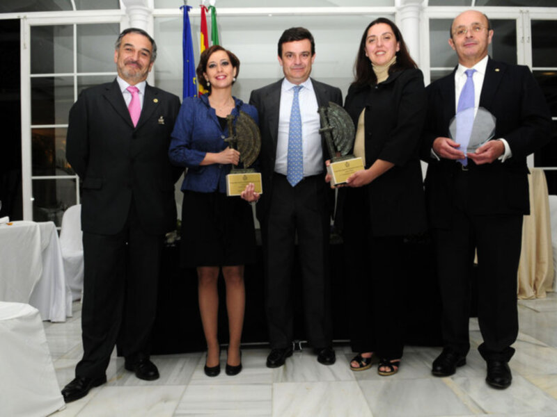 Un grupo de personas posando con sus premios en una ceremonia formal.