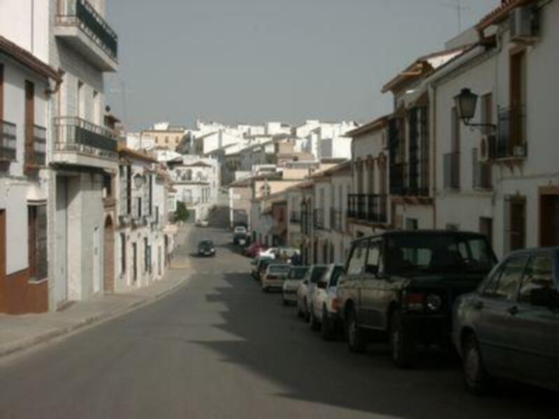 Elegantes edificios blancos con balcones y ventanas en una calle estrecha en un entorno urbano.