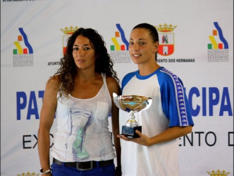 Dos atletas posan con un trofeo en un evento deportivo en Dos Hermanas, España.