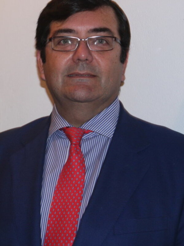 Un hombre con una camisa azul y una corbata roja, posando para una foto.