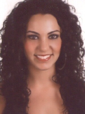 Una mujer con cabello oscuro y ondulado, sonriendo.