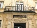 Entrada del Ayuntamiento de Sevilla, destacando su arquitectura clásica y balcones decorativos.