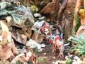 Representación de la natividad con figuras en un entorno rocoso y vegetal.
