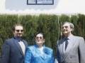 Tres personas posando juntas frente a una placa conmemorativa de la calle Juanita Rivas.