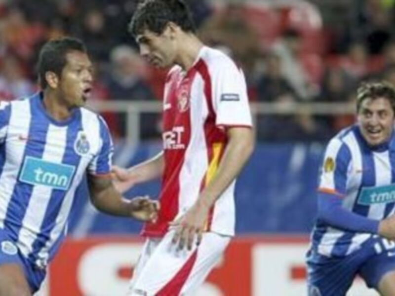 Un momento emocionante durante un partido de fútbol, con jugadores en acción y una bandera visible en el fondo.