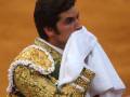 Matador en traje de luces con toalla en la mano, en un momento de la corrida de toros.