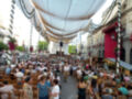 Feria de Sevilla, multitudinaria celebración con decoración festiva y público disfrutando en la plaza.