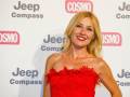 Una mujer con vestido rojo y peluca rubia posando en un evento de Jeep Compass y Cosmopolitan.