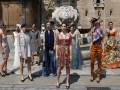 Modelos posando en una calle con vestidos de diferentes estilos, frente a un edificio histórico.