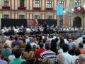 Concierto en plaza pública con público y orquesta.