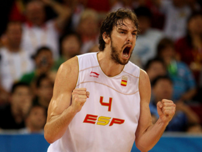 Un jugador de baloncesto gritando con los brazos levantados, con el escudo de España en su camiseta.