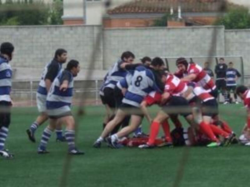 Jugadores de rugby en un scrum durante un partido, mostrando intensidad y cooperación.
