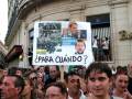 Manifestación contra la crisis financiera en Argentina, con carteles y personas protestando.