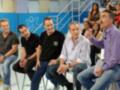 Grupo de personas sentadas en sillas, con un hombre en la derecha hablando y el resto escuchando, en un contexto de televisión o programa de entretenimiento.