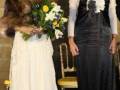 Dos mujeres elegantes posan juntas, una con un vestido blanco y la otra con un negro. La imagen transmite elegancia y posiblemente una celebración o evento formal.