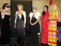 Quatro mulheres vestidas com vestidos elegantes em uma cerimônia formal.
