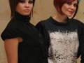 Dos modelos con cabello rojo y negro posan en una presentación de moda.