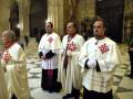 Religiosos en trajes litúrgicos en una catedral histórica.