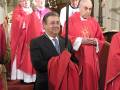 Celebración religiosa con sacerdotes vestidos en rojo y blanco.