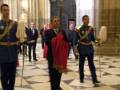 Guardias formales en uniforme militar, posando con un cetro y una bandera en la Catedral de Notre-Dame.