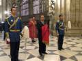 Guardias en uniforme dentro de una gran iglesia con vitrales y columnas.
