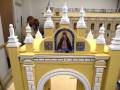 Un modelo en miniatura de una arquitectura histórica con detalles como la Virgen María y elementos decorativos.