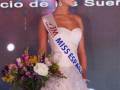 Miss España 2016 en un evento de belleza, con vestido blanco y ramo floral.