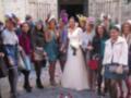 Bodas de invierno: novia y damas de honor con elegantes vestidos y tocados en una calle adoquinada.
