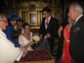 Una boda en un palacio con una novia y novio sonrientes, acompañados por amigos y familiares.