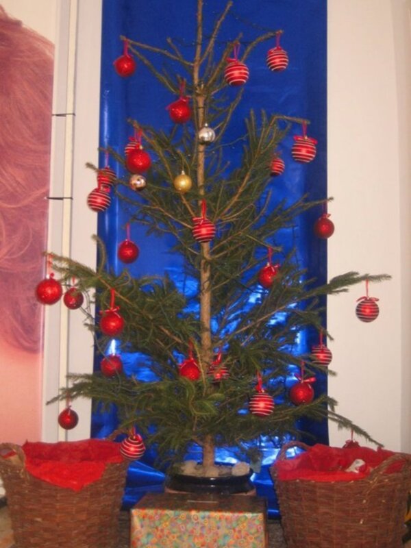 Árbol de Navidad con adornos rojos y decoraciones en un entorno festivo.