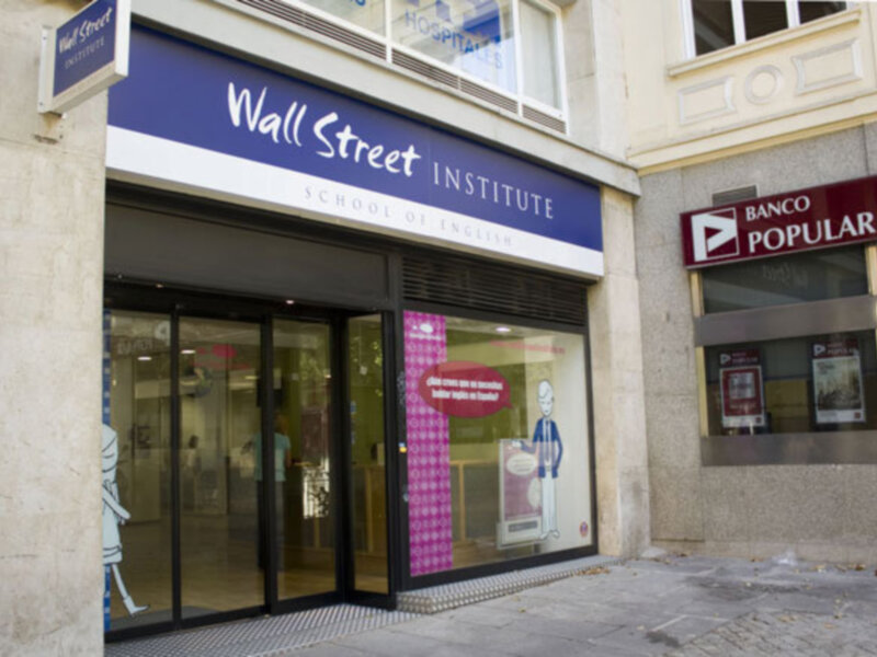 Fachada de un edificio con una tienda de Wall Street Institute y un banco Popular.