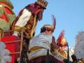 Imagen de un personaje vestido con trajes tradicionales, posiblemente en una celebración o desfile, con un fondo claro y azul.