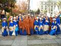 Una escena festiva con una agrupación de personas vestidas con trajes tradicionales, posiblemente en un evento cultural o histórico.