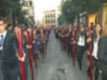 Una multitud de personas con bastones rojos en una calle, posiblemente durante un evento o manifestación.