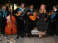 Grupo musical español interpretando flamenco al aire libre en una noche de verano.
