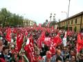Gran manifestación con banderas rojas y blancas en una calle urbana.