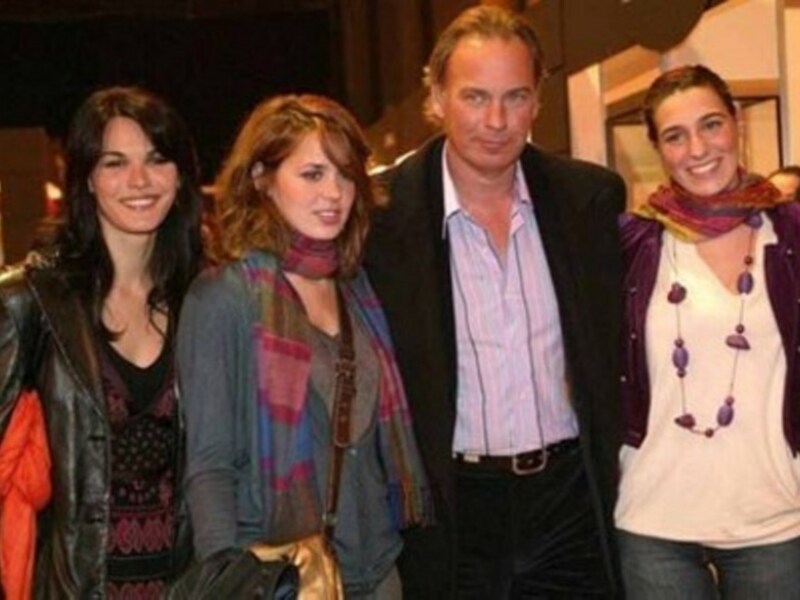 Una foto de grupo de tres mujeres y un hombre sonriendo y posando juntos.