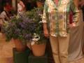 Mujer posando con flores y decoración navideña en un ambiente interior.