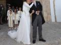 Novios saliendo de la iglesia tras su boda, con la novia en vestido blanco y el novio en traje negro.