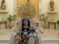 Imaginaria representación de una figura religiosa vestida con traje tradicional, posiblemente una Virgen, en un entorno de iglesia con elementos decorativos y estatuas.
