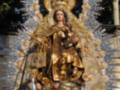 Imagen de la Virgen María con ornamentos dorados y detalles en color rojo.