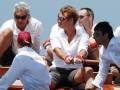 Un grupo de personas en un barco, algunos con gorras y gafas de sol.