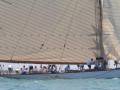 Barcos veleros en acción, con tripulaciones activas y vientos fuertes.
