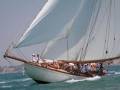 Barco de vela clásico navegando en el mar con una tripulación.