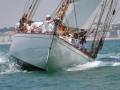 Barco navegando en aguas azules con una persona al frente.
