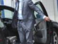 Un hombre en traje saliendo de un coche.