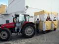 Tractor y carrito de frutas con toldo amarillo y blanco en una calle pavimentada.