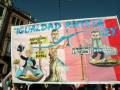 "¡IGUALDAD ANTE LA LEY!" muestra una protesta con dos personajes caricaturizados: uno sosteniendo un arco y otro con una cesta de compras. El texto sugiere una crítica a la desigualdad en el sistema financiero y legal, destacando la resiliencia de las banqueras frente a los bancos.