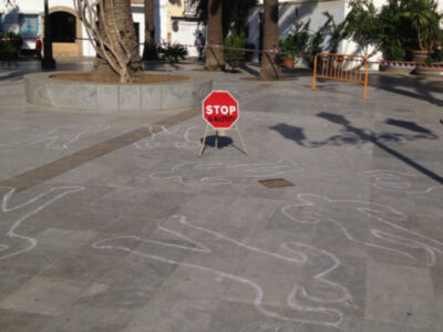 Un stop sign en el centro de una calle con grafitis y un carrilón.