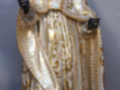 Estatua de un sacerdote vestido con una túnica dorada y una saya, posiblemente representando a San Pablo. La imagen muestra la figura del sacerdote con una expresión serena y un gesto de bendición. La escultura parece estar hecha en madera o algún material similar, con detalles finos y un acabado brillante.